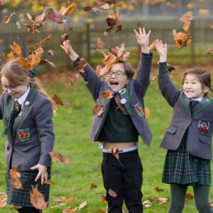 students throwing leaves in the air